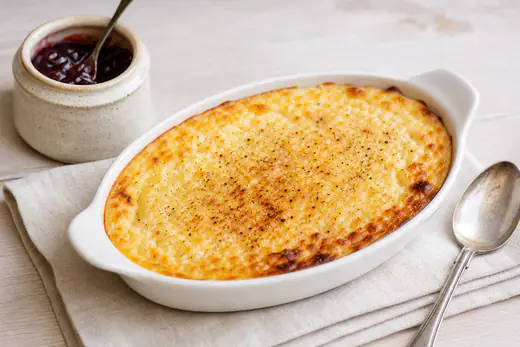 A creamy baked rice pudding with a golden skin and grated nutmeg in a white ovenproof dish