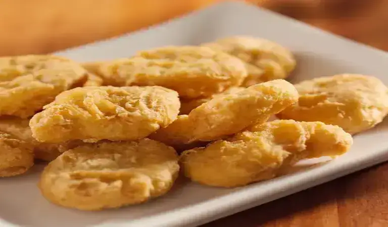 Chicken nuggets in air fryer served on a plate with dip