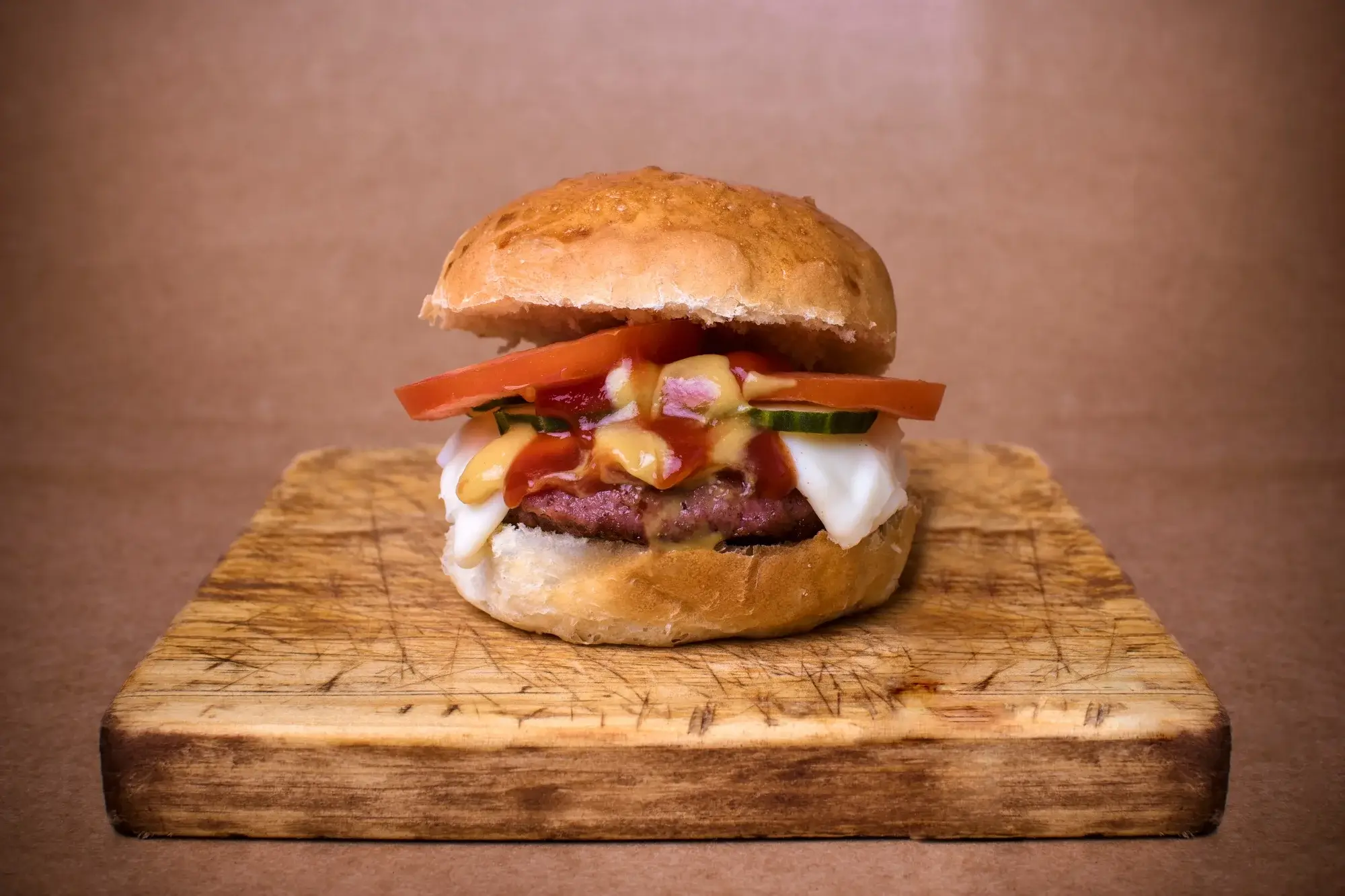 Juicy hamburger in air fryer with melted cheese and fresh toppings