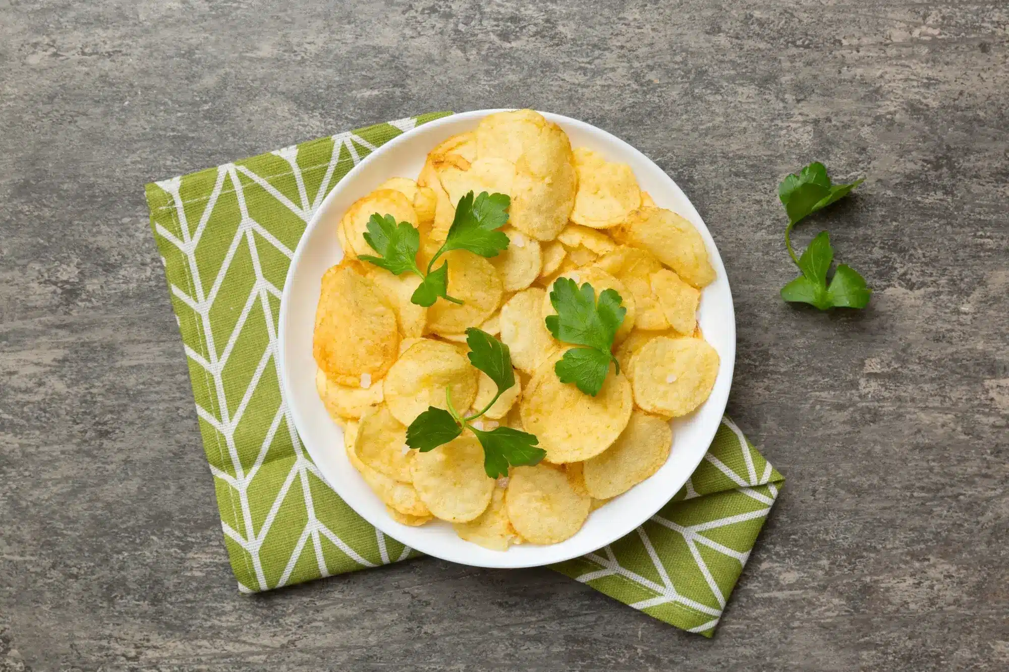 Crispy golden potato chips in air fryer on a plate