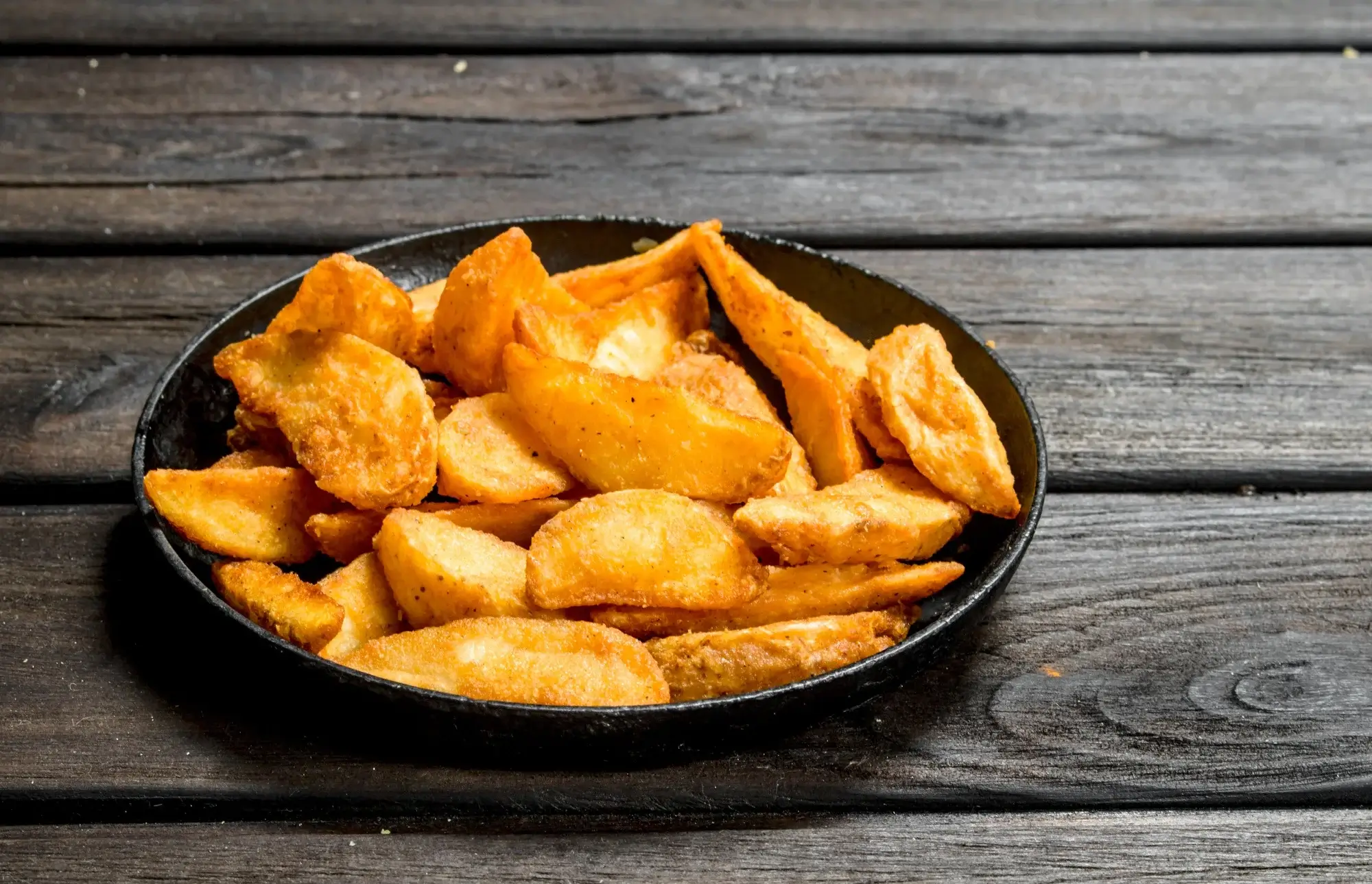 Crispy potato slices in air fryer served on a plate
